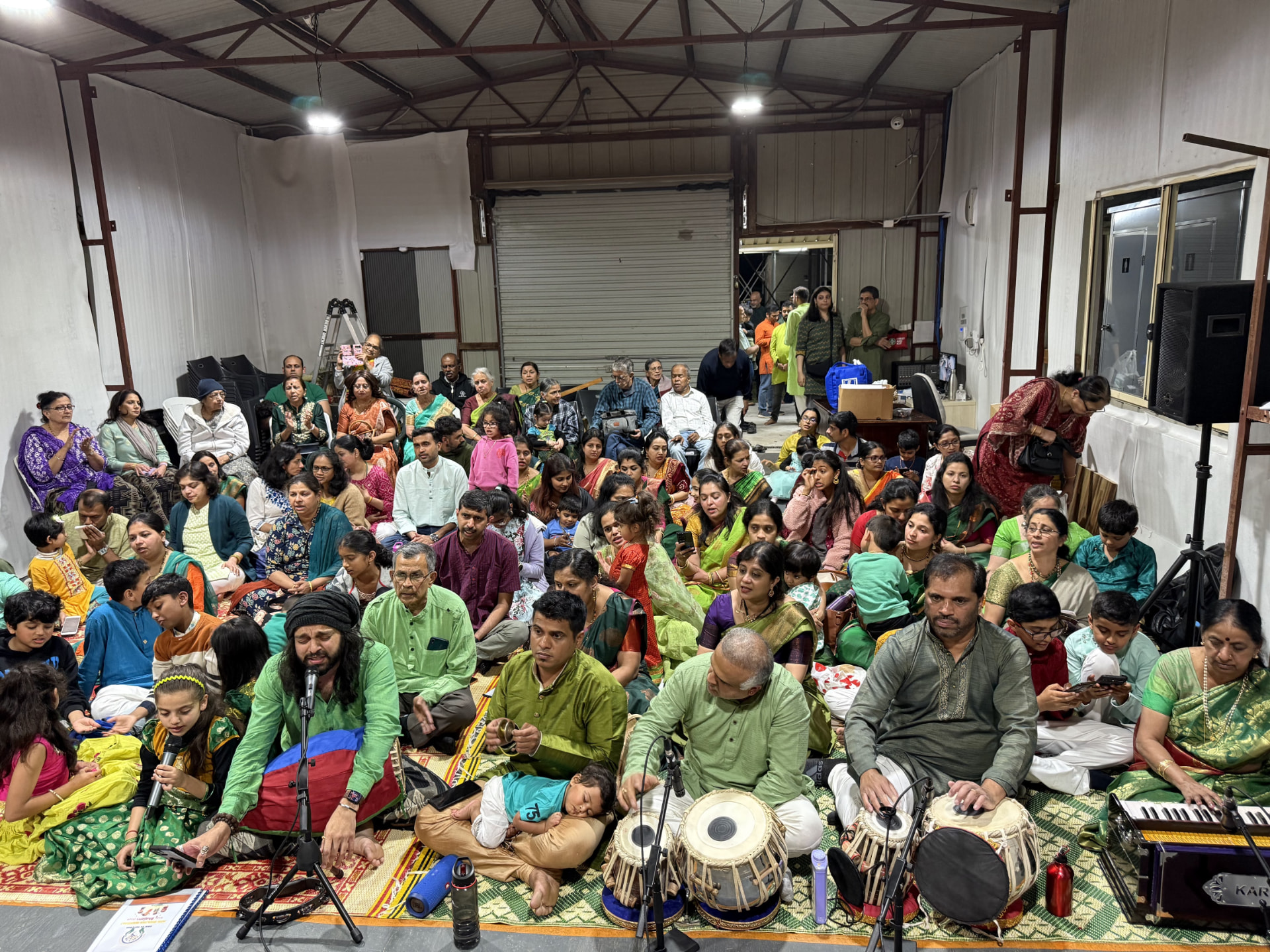 A packed hall for the Navaratri bhajan sabha — every generation singing together