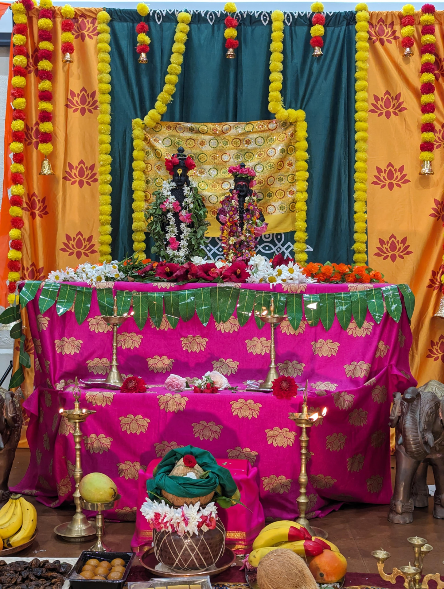 Shri Vitthal and Rakhumai adorned with garlands, lamps and mango-leaf toran